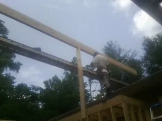 Carpenter setting a ridge beam over a new addition frame — Ice Dam Removal by Roofing Brothers in Barrett