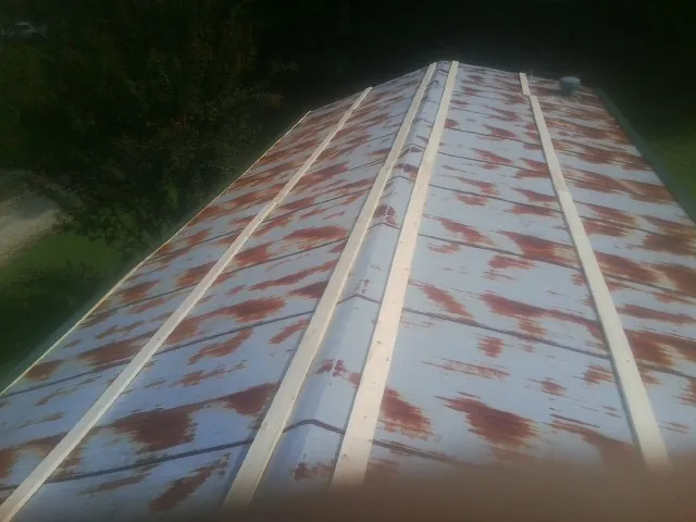 Rusted metal roof panels with new wood purlins before replacement — Storm Damage Roof Repair in Barrett by Roofing Brothers