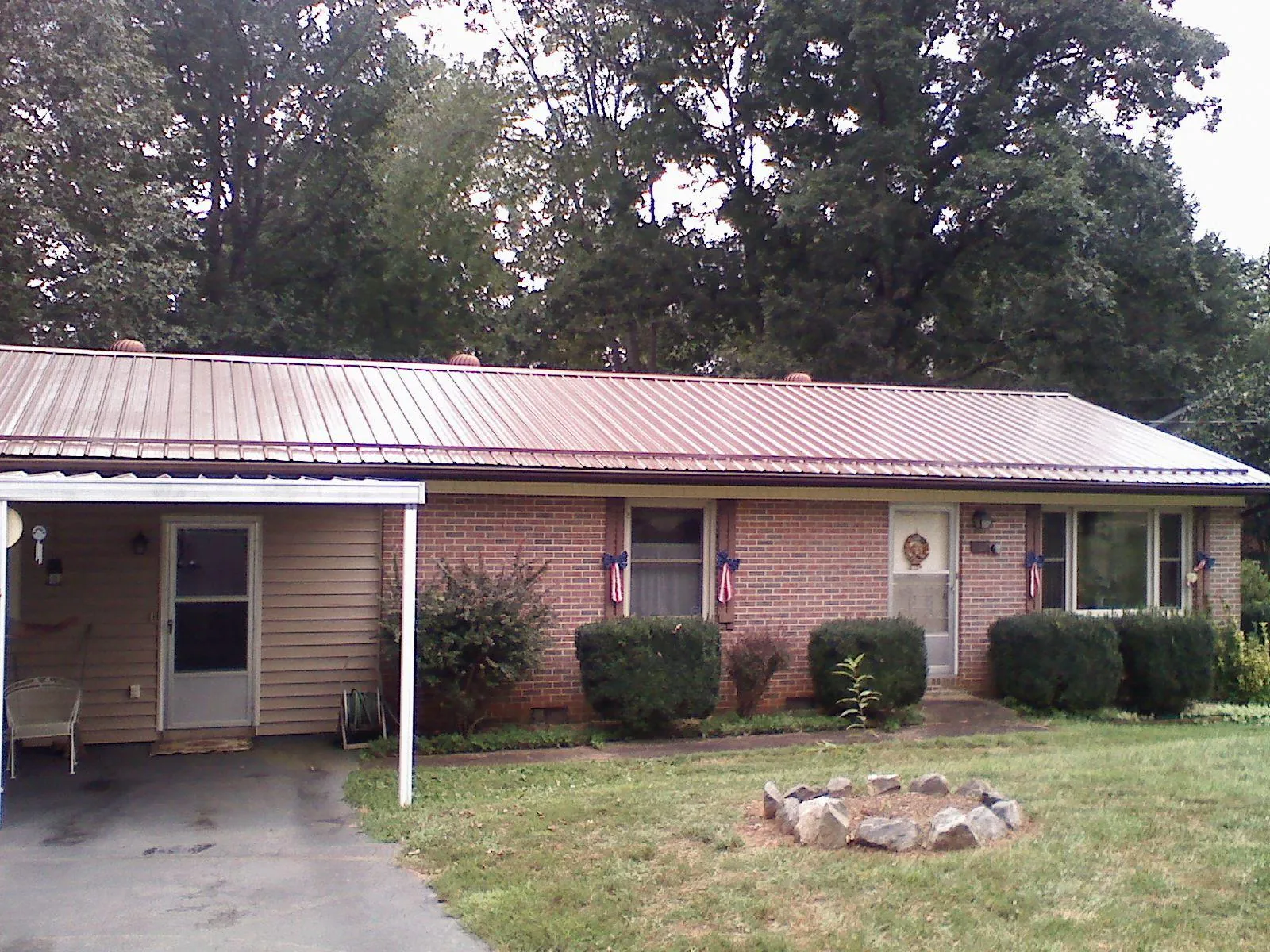Bronze metal roof and carport on a brick ranch home — Roof Repair work by our crew in Barrett