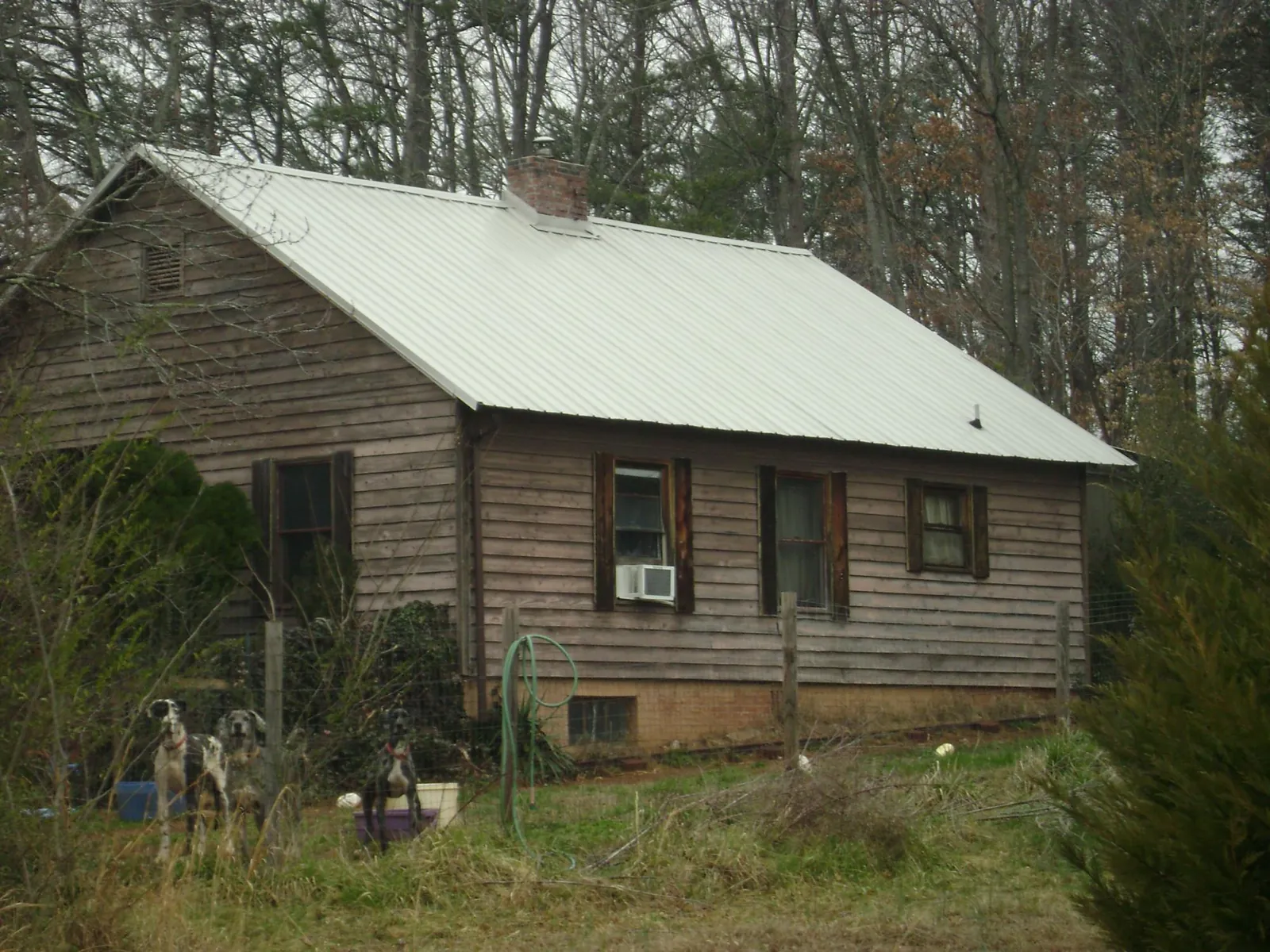 White metal roof on an old wood sided farmhouse, from a Metal Roof Installation job in Barrett